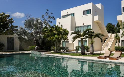 a villa with a swimming pool in front of a building at Villas H2O in Tulum