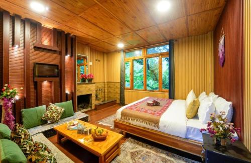 a bedroom with a bed and a living room at Sony Place Villa and Resort in Kasol