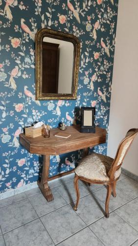 a desk with a mirror and a chair in a room at Gite de Lavardin in Saint-Aubin-de-Locquenay