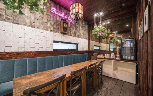 a dining room with a long wooden table and chairs at Daegu February Hotel Hwanggeum in Daegu