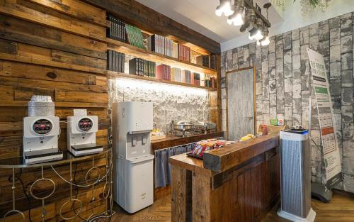 a kitchen with wooden walls and a refrigerator and a counter at Daegu February Hotel Hwanggeum in Daegu
