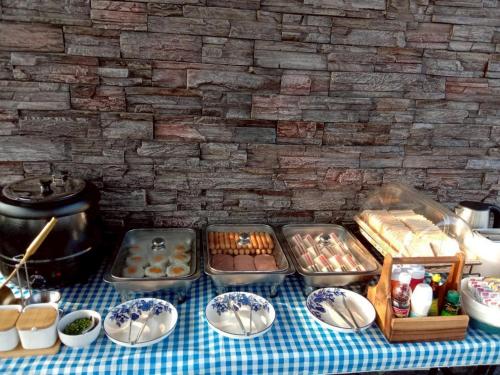 a table topped with plates and bowls of pastries at S HOUSE POOLVILLA Khaoyai in Pak Chong