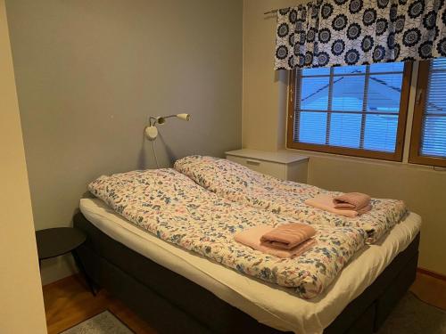 a bed with two towels on it in a bedroom at Levin Alppi in Levi