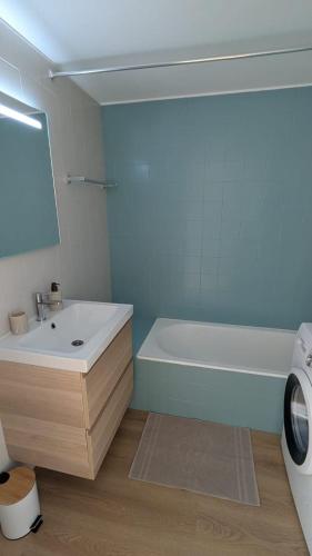 a bathroom with a white tub and a sink at Penthouse Studio Sea View in Alvor