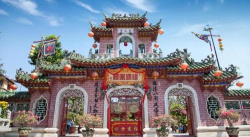 a building with an asian inspired architecture with flowers at Hoi An Paradise Villa in Hoi An