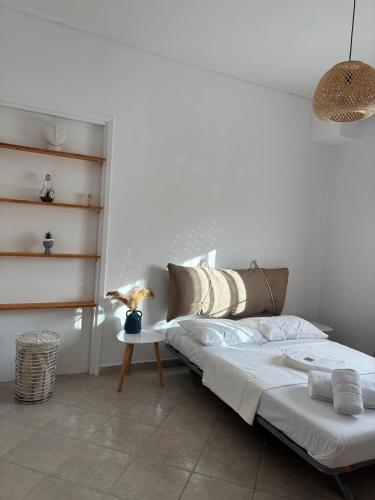 a white bedroom with a bed and a table at Soul Home in Iraklitsa