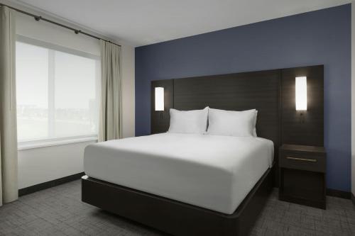 a large white bed in a room with a window at Residence Inn by Marriott Dayton Miamisburg in Miamisburg