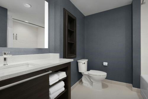 a bathroom with a toilet and a sink and a mirror at Residence Inn by Marriott Dayton Miamisburg in Miamisburg
