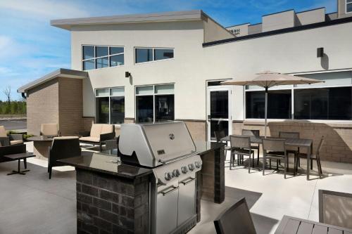 an outdoor patio with a grill and tables and chairs at Residence Inn by Marriott Dayton Miamisburg in Miamisburg