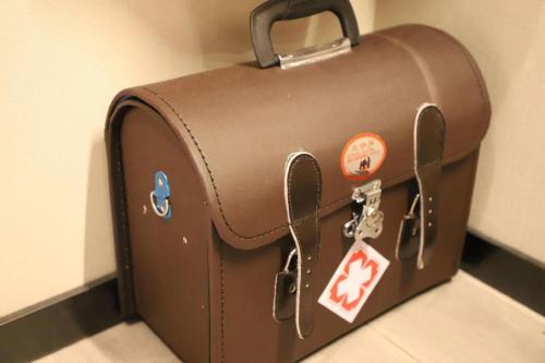 a brown suitcase with stickers on the side of a wall at Ethos Hotel Wuhan Riverside in Wuhan