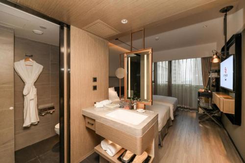 a bathroom with a sink and a mirror at Ethos Hotel Wuhan Riverside in Wuhan