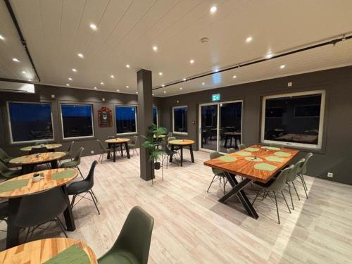 a dining room with tables and chairs and windows at Reinebua in Reine