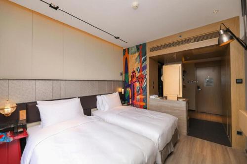 two white beds in a room with a kitchen at Ethos Hotel Wuhan Riverside in Wuhan