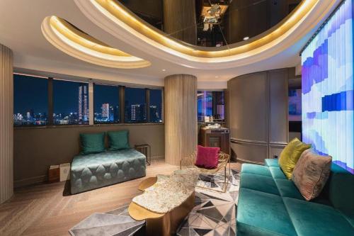 a living room with a couch and a tv at Ethos Hotel Wuhan Riverside in Wuhan