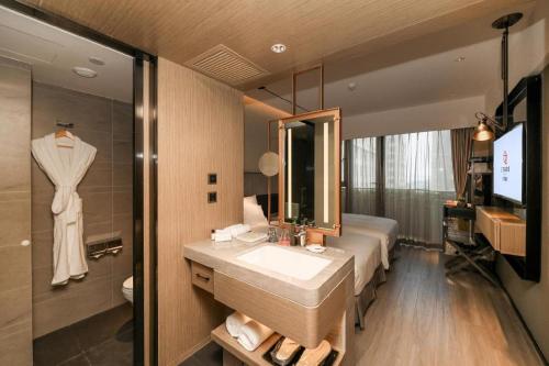 a bathroom with a sink and a mirror at Ethos Hotel Wuhan Riverside in Wuhan