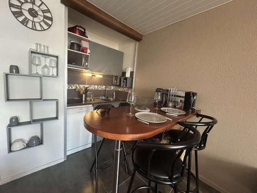 une cuisine avec une table, des chaises et une horloge murale dans l'établissement Appt Deux pièces 4 couchages CAP D'AGDE CT455-146, au Cap d'Agde