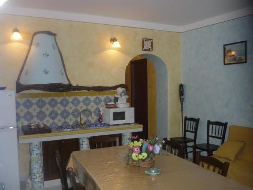 a living room with a table and a microwave at Casa Vacanze Central Cincotta in Lipari