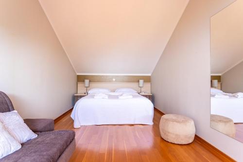 a bedroom with a bed and a couch at Apartments Lavica Beach Dumičić in Podstrana