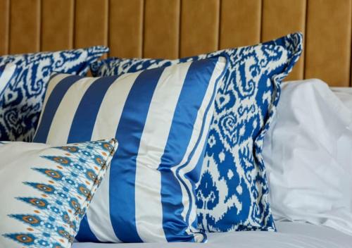 a group of blue and white pillows on a bed at St Brides Spa Hotel & Village Apartments in Saundersfoot