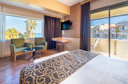 una habitación de hotel con una cama y una silla en Fame Beach Hotel, en Kemer