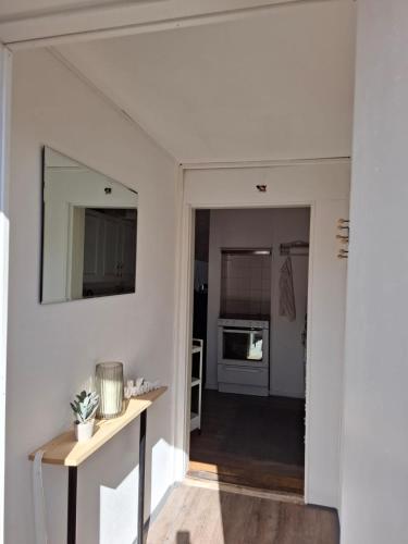 a living room with white walls and a mirror at Ferienhaus am See (Rådasjön) in Råda