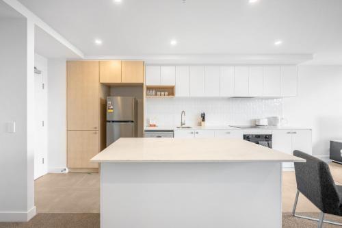 a kitchen with white cabinets and a white counter top at Self-Contained Apartment in Woden By Serain in Phillip