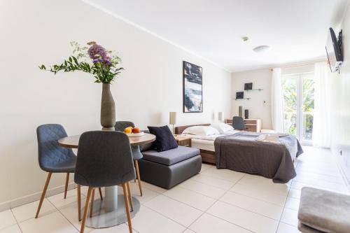 a living room with a bed and a table and chairs at Apartments Lavica Beach Dumičić in Podstrana