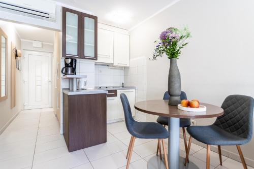 a kitchen with a table and chairs and a vase with flowers at Apartments Lavica Beach Dumičić in Podstrana
