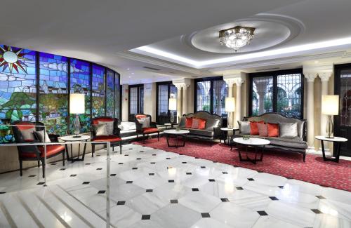 a lobby with couches and tables and a stained glass window at Eurostars Conquistador in Córdoba