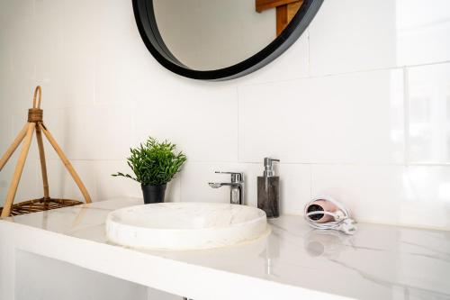 a bathroom counter with a sink and a mirror at Villa Primarosa - Charming 3BR Villa with rooftop in Munggu