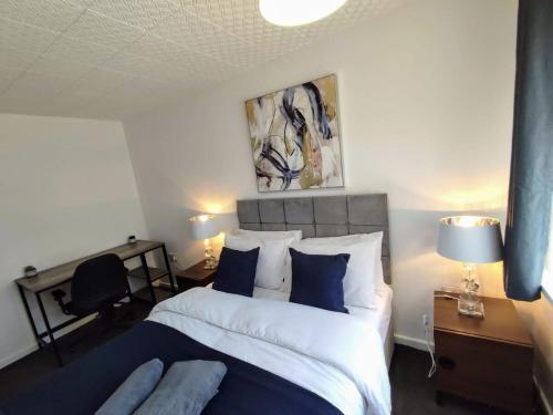 a bedroom with a large bed with blue and white pillows at Sigma Haven, Free Parking in Old Walker