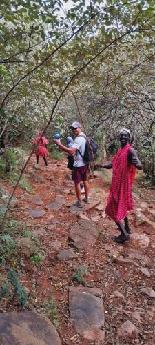 a group of people walking down a dirt trail at KANUNKA HOUSE in Sekenani