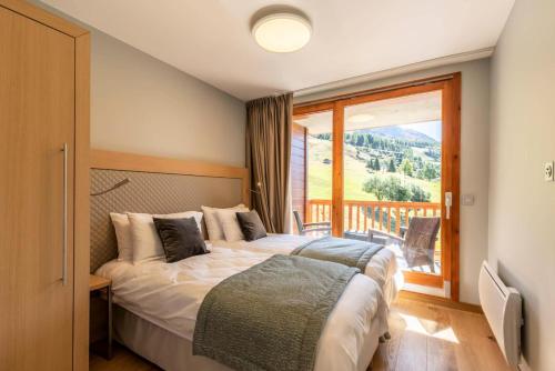 une chambre avec un lit et une grande fenêtre dans l'établissement Résidence Les Monarques - MONARQUES 1003 MAE-0111, à Arc 1800