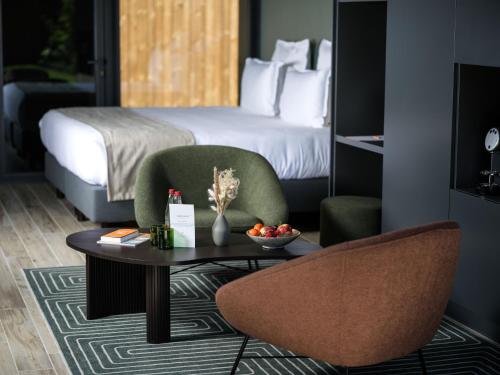 a hotel room with a bed and a table and chairs at Domaine Le Verbois in Chantilly