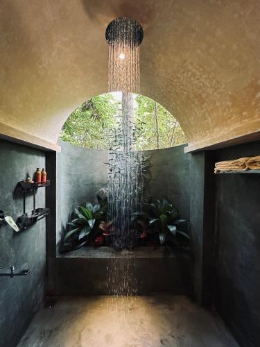 a large water fountain in a room with plants at Dunes Unawatuna Hotel in Unawatuna
