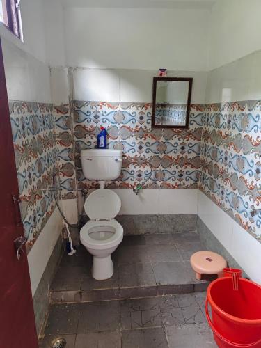 a bathroom with a toilet and a mirror at Nanda rawat Homestay in Munsyari