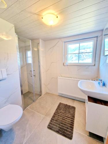 a bathroom with a toilet and a sink and a shower at Ferienwohnungen Claudia in Altossiach