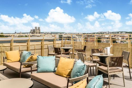 a patio with chairs and tables on a roof at Holiday Inn Express & Suites Reims - Rives de Vesle by IHG in Reims