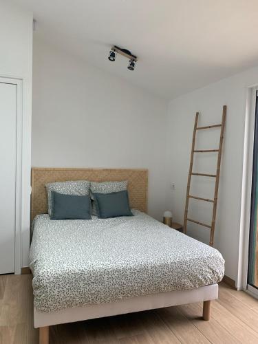- une chambre avec un lit doté d'oreillers bleus et d'une échelle dans l'établissement Studio neuf avec Terasse Jardin, à Seignosse
