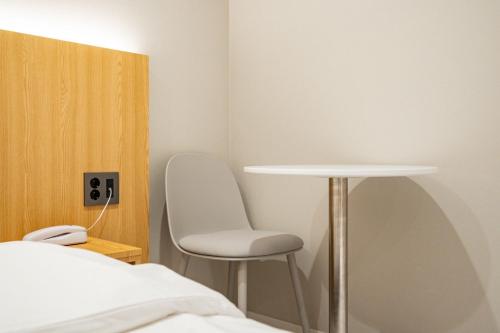 a room with a bed and a table and a chair at Cream Hotel in Guri