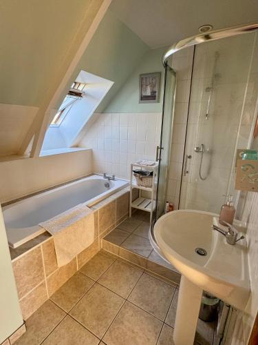 une salle de bain avec une baignoire et un lavabo dans l'établissement Chambre de Ninon - Le Refuge des Parachutistes - en bordure du marais, à Neuville-au-Plain