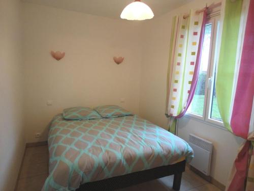 - une chambre avec un lit et une fenêtre avec des coeurs sur le mur dans l'établissement Jolie maison de vacances secteur Mouettes, à Saint-Jean-de-Monts