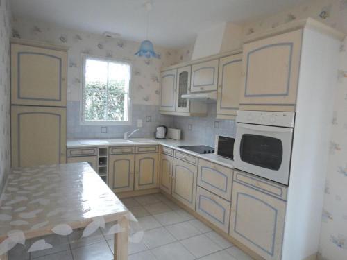 - une cuisine avec des appareils électroménagers blancs et une table dans l'établissement Jolie maison de vacances secteur Mouettes, à Saint-Jean-de-Monts