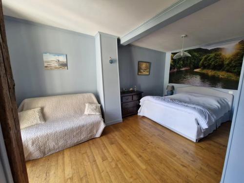 a bedroom with a bed and a couch and a chair at Maison La Flambée in Bordères-Louron