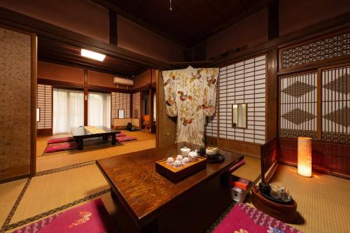 a room with a wooden table in a room at 顔house 若水庵 築100年の古民家ステイ 北総の田園に佇む和の隠れ家 最大12名宿泊可 in Katori