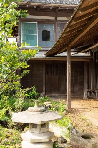 a stone bench in front of a house at 顔house 若水庵 築100年の古民家ステイ 北総の田園に佇む和の隠れ家 最大12名宿泊可 in Katori