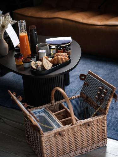 a table with a basket of bread and a plate of food at Domaine Le Verbois in Chantilly