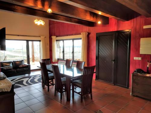 une salle à manger avec des murs rouges, une table et des chaises dans l'établissement La Casona del Silencio, à Aldehuela de Periañez