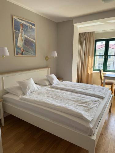 a bedroom with a large bed with white sheets at Villa Alexandra in Świnoujście
