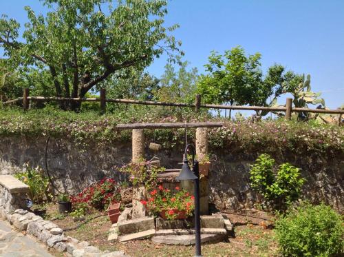 a garden with flowers and a stone wall at B & B Korello in Gasponi